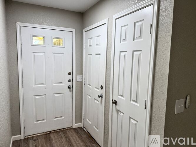 Two white doors with windows and handles.