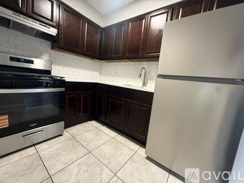 A kitchen with a stove, refrigerator, and brown cabinets.
