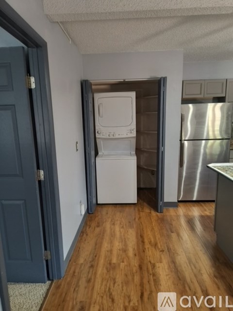 A kitchen with a white dishwasher and a silver refrigerator.