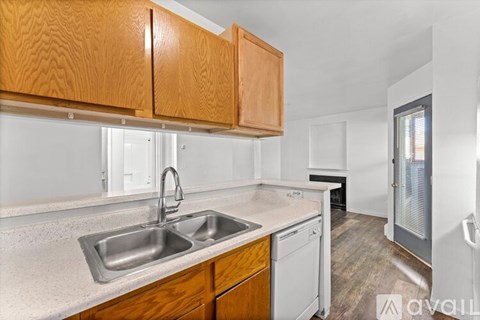 A kitchen with wooden cabinets and a white sink.