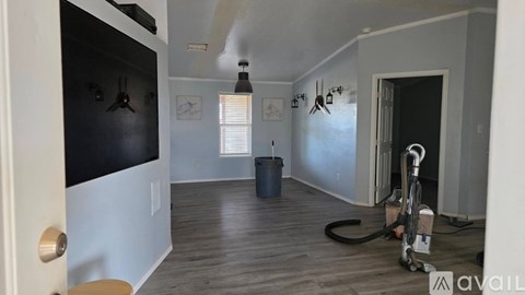 A room with a vacuum cleaner and a trash bin.