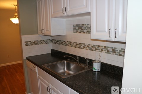 A kitchen with a sink and a can of beer on the counter.