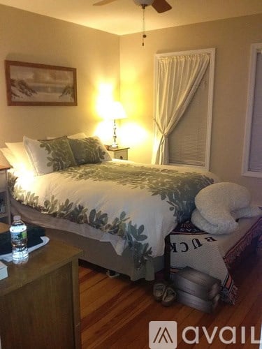 A bedroom with a bed, nightstand, and a ceiling fan.