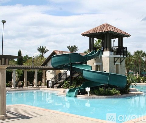 A large green water slide in a pool.