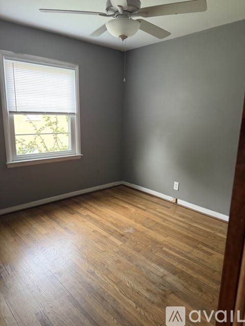 A room with wooden flooring and a ceiling fan.