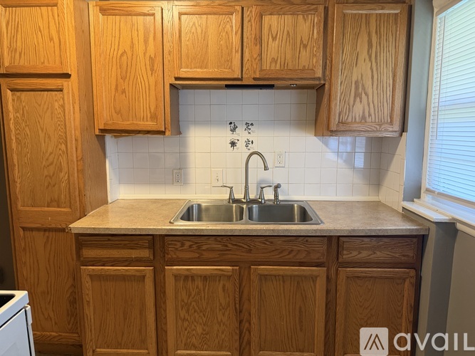 A kitchen with wooden cabinets and a white dishwasher.