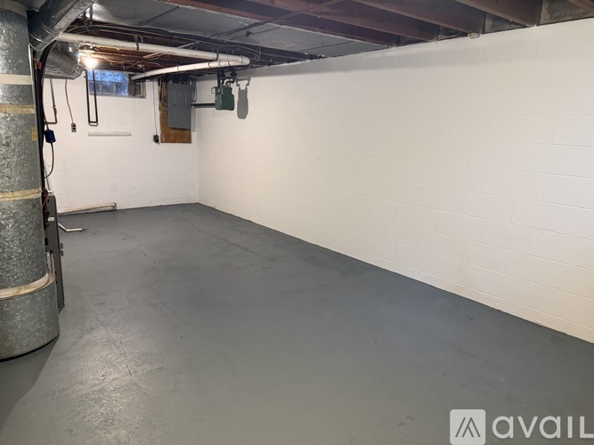 A spacious basement with a concrete floor and white walls.