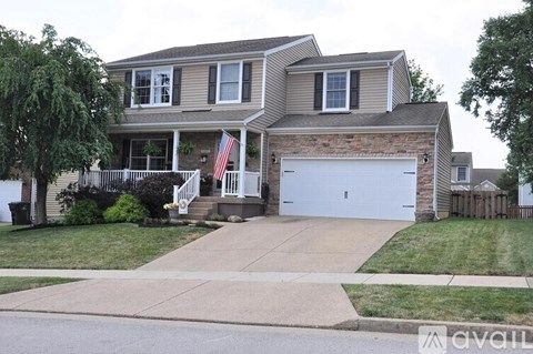 A two-story house with a garage and a flag on the front porch.