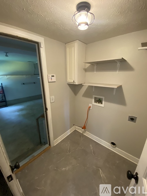 A small, empty room with a door and a window.