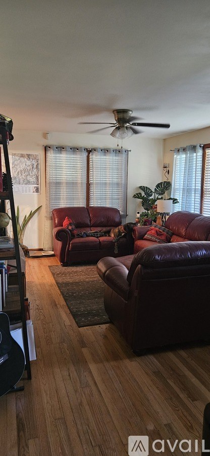 A living room with a red couch and a ceiling fan.