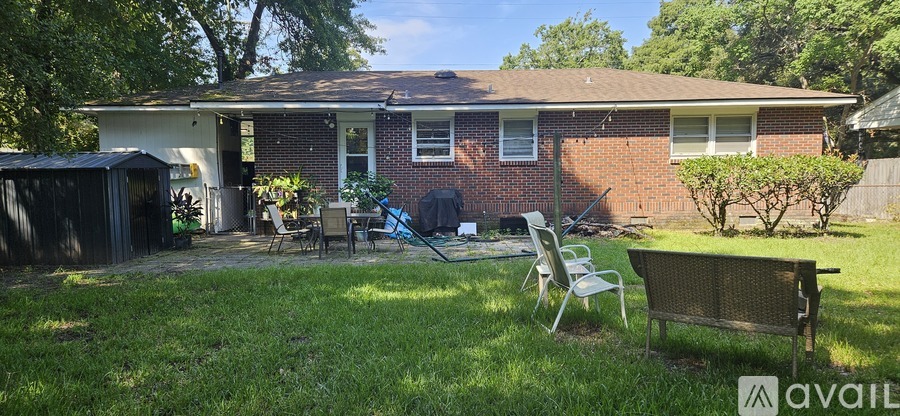 A backyard with a lawn, a bench, and a shed.