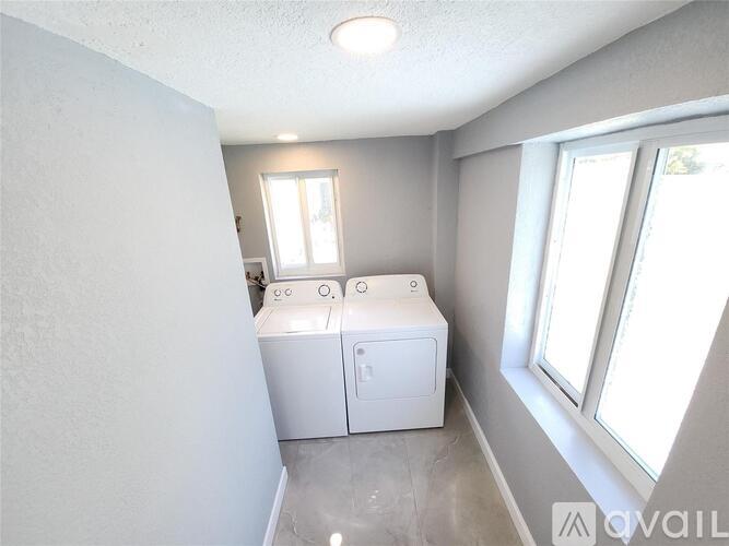 A small white laundry room with a washer and dryer.