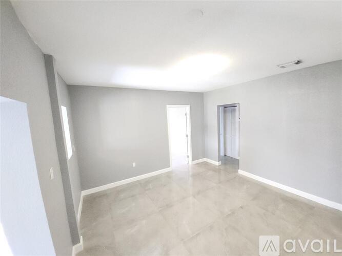 A spacious room with a door and a window.