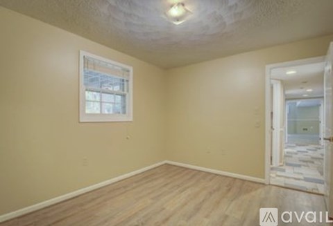 A room with a window and wooden flooring is available for rent.