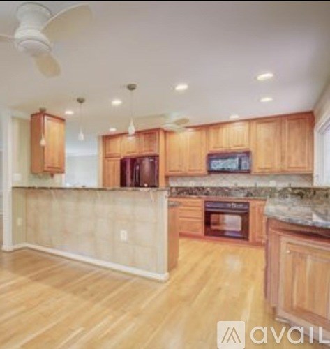 A kitchen with wooden cabinets and a marble countertop.