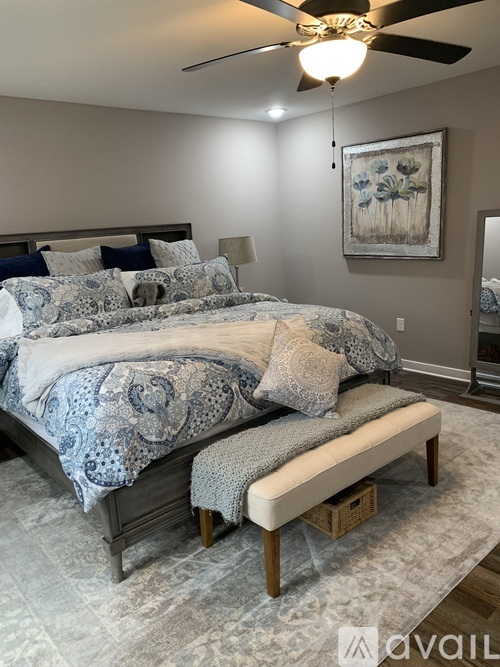 A bedroom with a large bed and a ceiling fan.