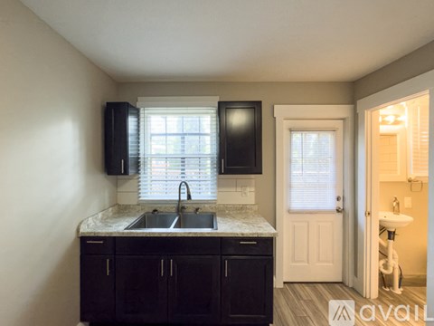 A kitchen with black cabinets and a marble countertop.