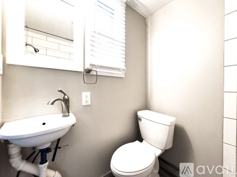 A white toilet sits next to a sink in a bathroom.