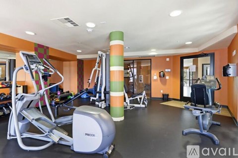 A gym with a variety of equipment including treadmills, stationary bikes, and weight machines.