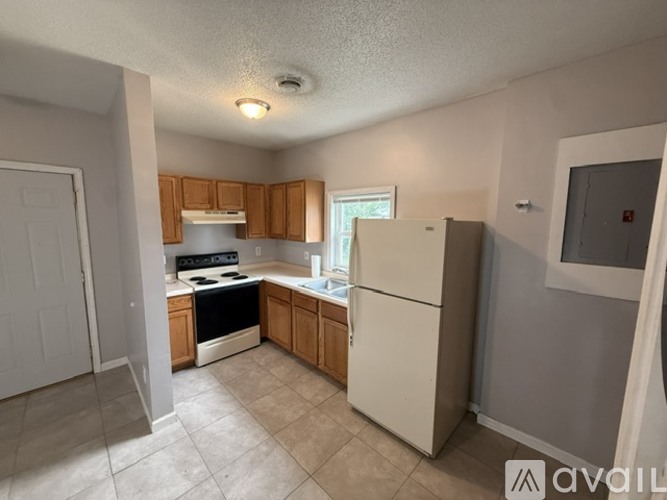 A kitchen with a white refrigerator, white oven, and wooden cabinets.