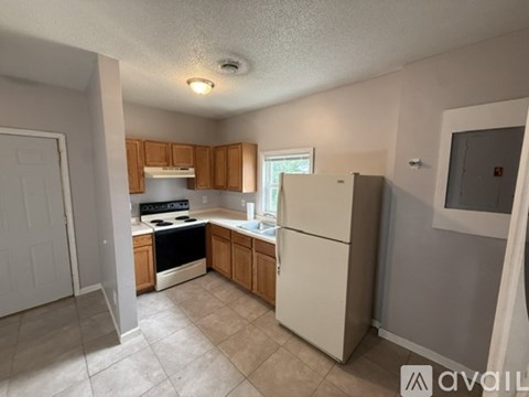 A kitchen with a white refrigerator, white oven, and wooden cabinets.