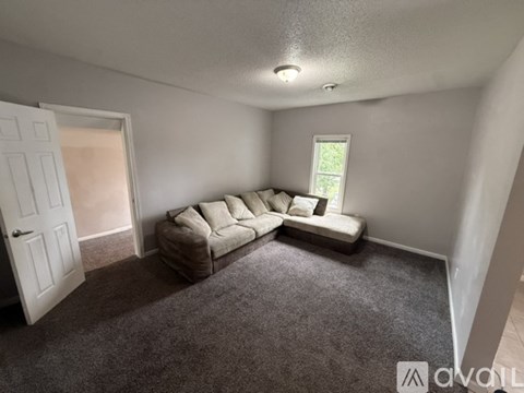 A living room with a couch and a window.