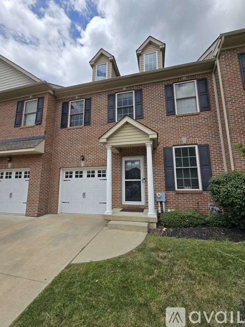 A brick house with a white garage door and a small porch.