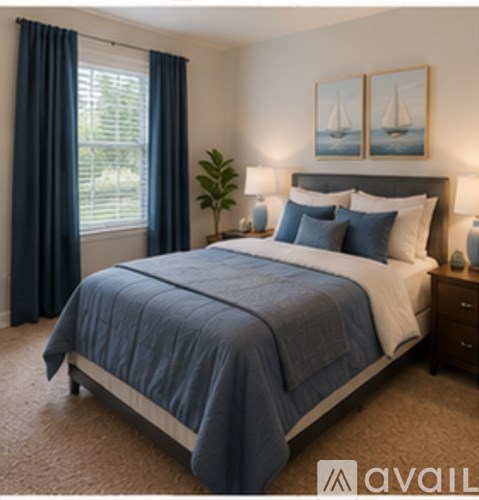 A bedroom with a large bed and a window with blue curtains.