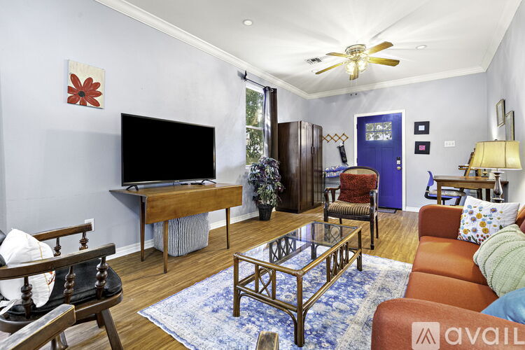 A living room with a television, a chair, a sofa, and a coffee table.