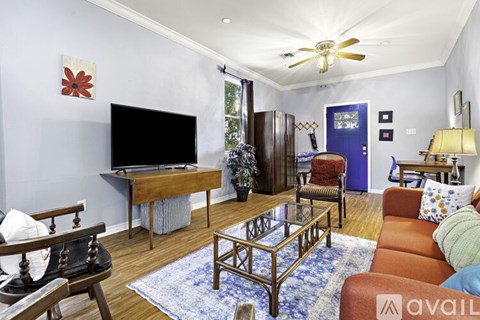 A living room with a television, a chair, a sofa, and a coffee table.