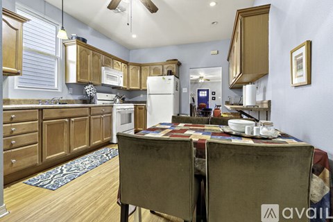 A kitchen with wooden cabinets and a table with a cloth on it.