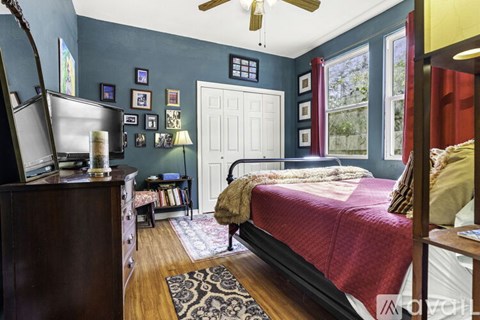 A bedroom with a bed, dresser, and ceiling fan.