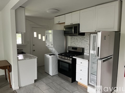 A kitchen with white appliances and cabinets.