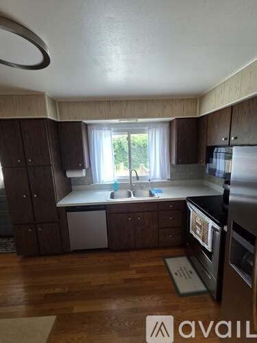 A kitchen with wooden cabinets and a window.