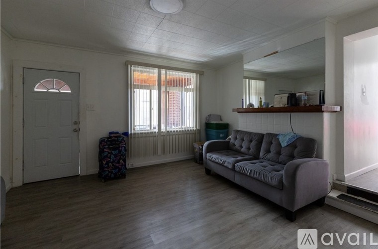 A living room with a grey couch and a wooden floor.