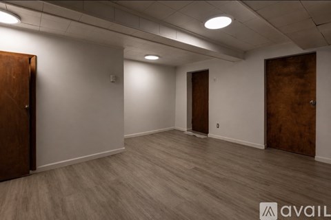 A room with wooden floors and two brown doors.