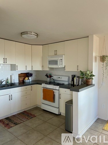 A kitchen with white cabinets and a black countertop.