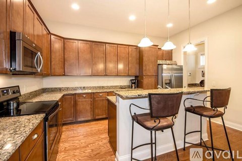 A kitchen with brown cabinets and a granite countertop.
