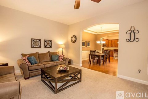 A living room with a brown couch and a wooden coffee table.