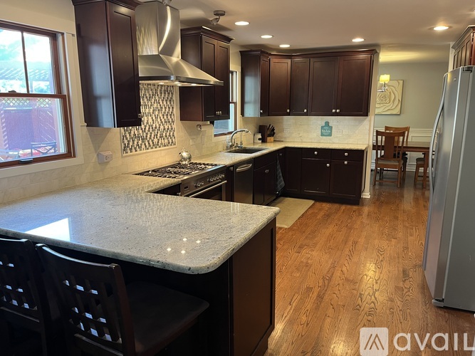 A kitchen with dark wood cabinets and a white countertop.
