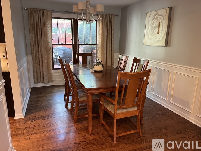 A dining room with a wooden table and chairs.