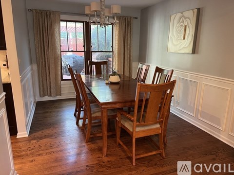 A dining room with a wooden table and chairs.