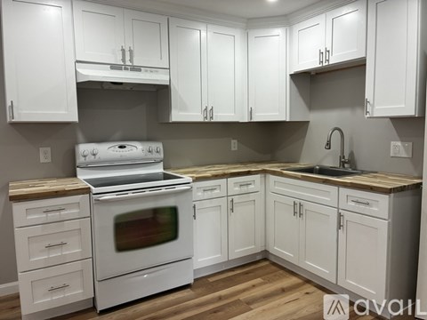A kitchen with white cabinets and a white oven.
