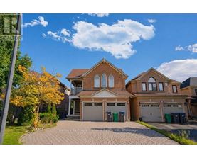 A large house with a brick facade and a driveway in front.