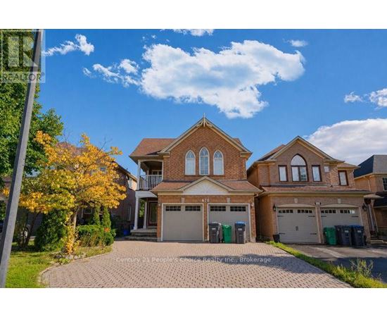 A large house with a brick facade and a driveway in front.