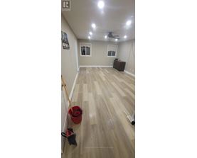 A room with a ceiling fan and a wooden floor.