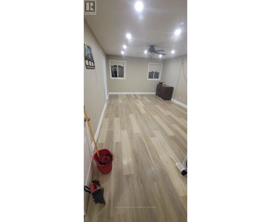 A room with a ceiling fan and a wooden floor.