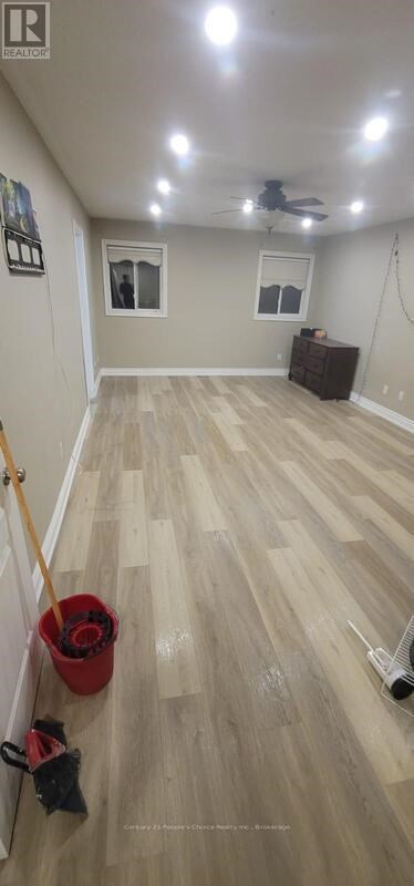 A room with a ceiling fan and a wooden floor.
