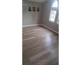 A room with wooden flooring and a window.