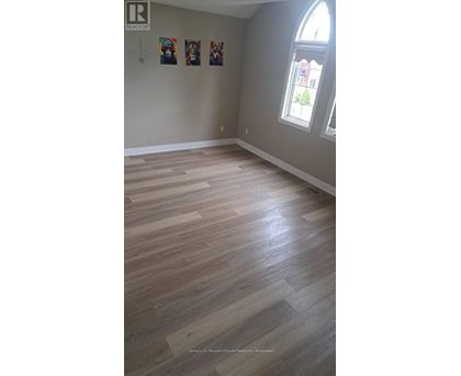 A room with wooden flooring and a window.